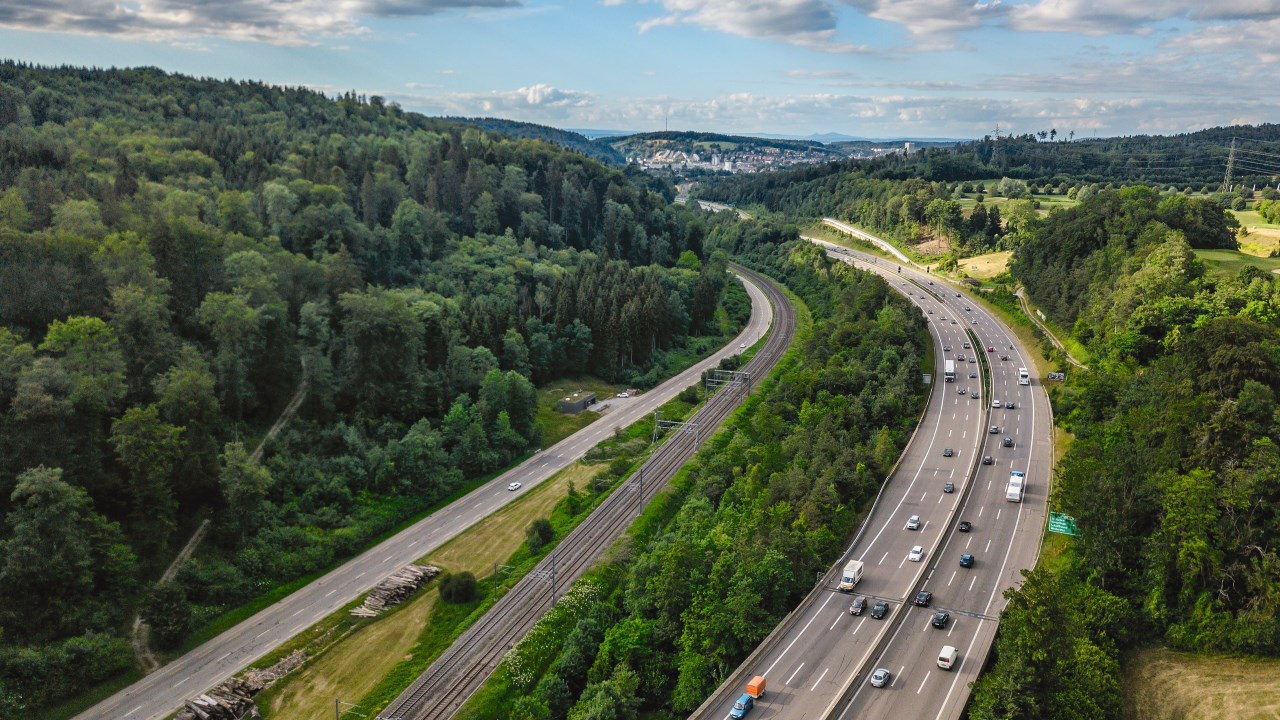 Nicht nur in den Alpen, sondern auch im Mittelland – der kopflose Autobahnausbau gefährdet die Verlagerung auf die Schiene, obwohl die entsprechende Infrastruktur vorhanden ist.